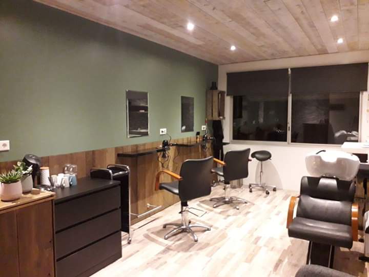 Interieur van 't Knipschuurtje in Netersel, kappersstoelen tegen een salie-groene wand